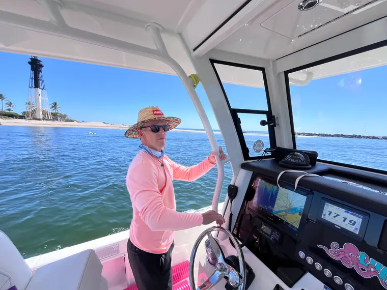 Lulu Boat Charter captain at the helm near Hillsboro Lighthouse