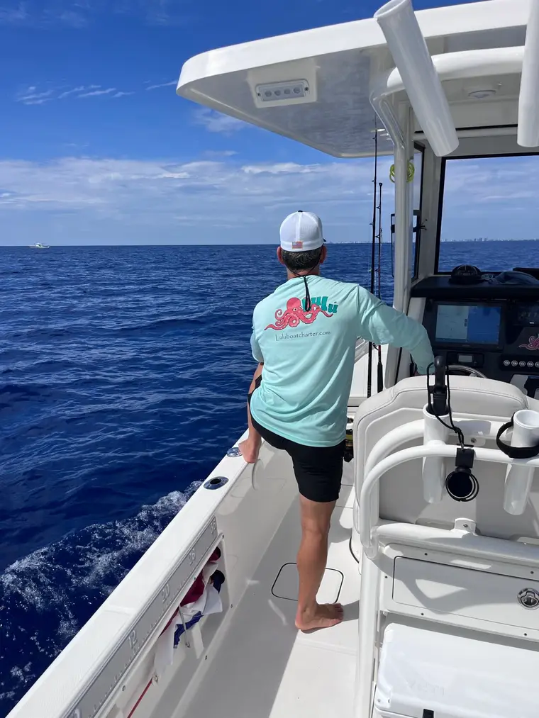 Captain in a Lulu Boat Charter shirt scanning the water offshore of Fort Lauderdale