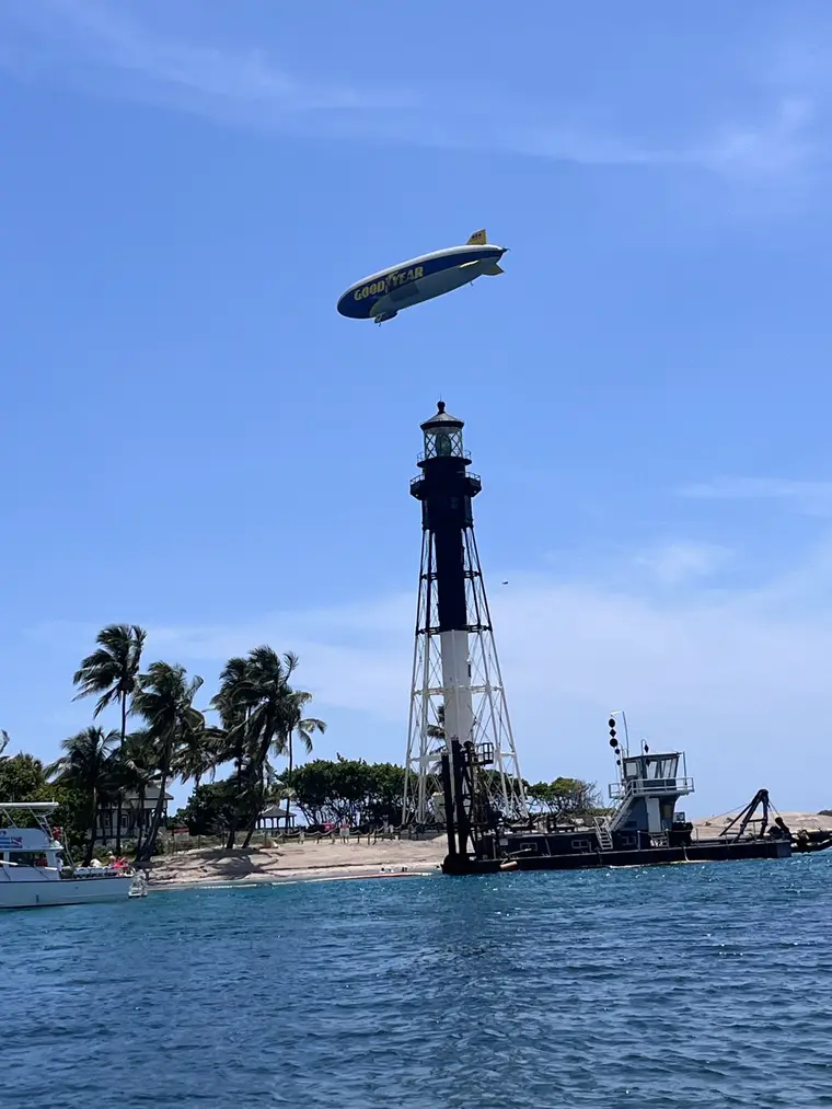 Hillsboro Lighthouse and the Goodyear blimp seen from the water