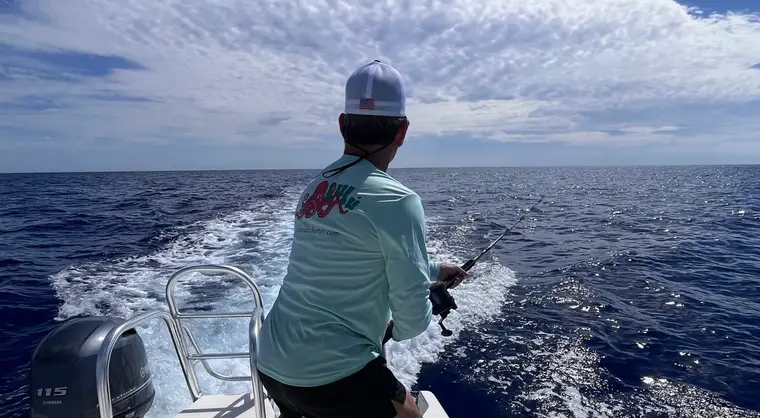 Angler working a rod off the stern during an offshore fishing charter