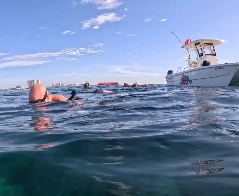 Snorkelers floating alongside the Lulu with the Pompano Beach shoreline behind
